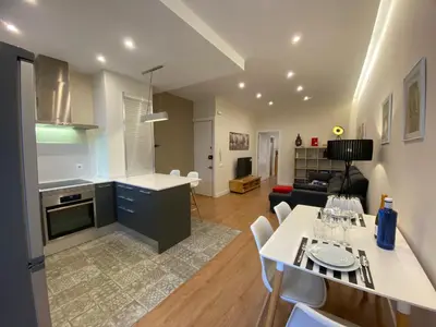 a kitchen and living room with a table and chairs at Spatious luxe apartment Paseo de Gracia Diagonal in Barcelona