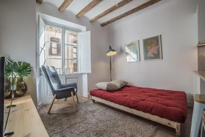 a bedroom with a red bed and a chair at Welcomy Born in Barcelona