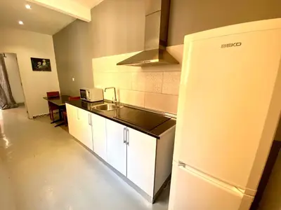 a kitchen with a white refrigerator and a table at Apartamento de 3 habitaciones en Sants a 2`del metro Badal P9 in Barcelona