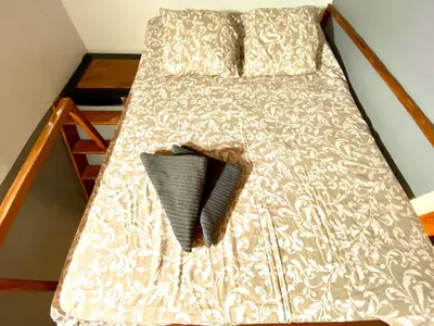a bed with a gray and white comforter and pillows at Apartamento de 3 habitaciones en Sants a 2`del metro Badal P9 in Barcelona
