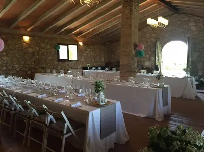 a room with white tables and chairs in a building at Can Vidal in Subirats
