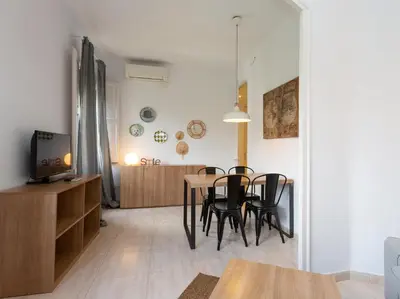 a dining room and living room with a table and chairs at Centric Sagrada Familia Apartments in Barcelona