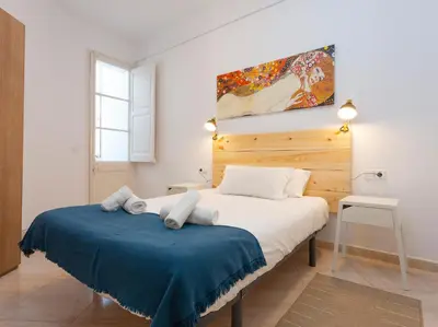 a bedroom with a bed with a blue blanket at Centric Sagrada Familia Apartments in Barcelona