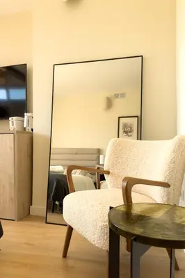 a living room with a mirror and a chair and a table at Boutique Design Apartments & Studios in Barcelona