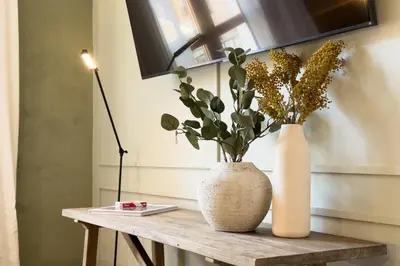 two vases sitting on a wooden table with flowers at Boutique Design Apartments & Studios in Barcelona