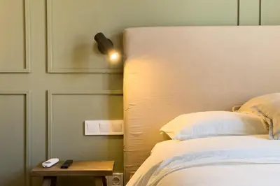 a bed with a headboard and a table next to it at Boutique Design Apartments & Studios in Barcelona
