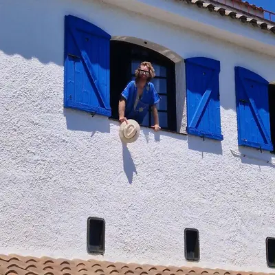 a person looking out the window of a building at Villa Alella, 5 bedrooms & pool in Alella