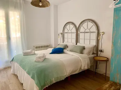 a bedroom with a large white bed with blue pillows at Dolce Terrassa 25 min Barcelona and Beach in Terrassa