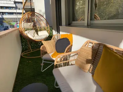 a balcony with chairs and wicker chairs and a bench at Dolce Terrassa 25 min Barcelona and Beach in Terrassa