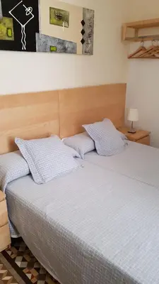 two beds sitting next to each other in a bedroom at Hostal Eixample in Barcelona