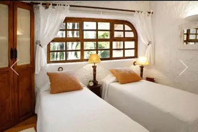 two beds in a room with a window at La Ginesta Rural, cerca de Sitges in Canyelles