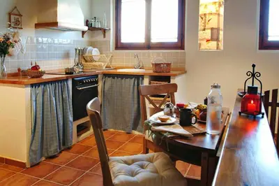 a kitchen with a wooden table and a table and a dining room at La Ginesta Rural, cerca de Sitges in Canyelles