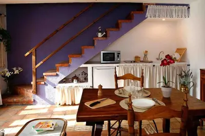 a dining room with a table and a staircase at La Ginesta Rural, cerca de Sitges in Canyelles