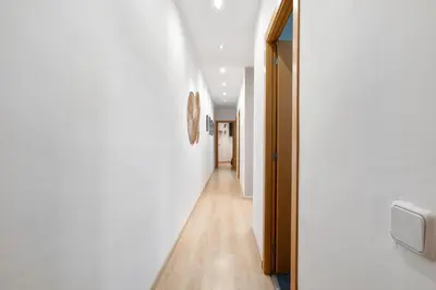 a hallway with white walls and a wooden floor at Lodging Apartments Villarroel apartment in Barcelona