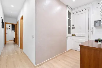 an empty hallway with white walls and a door at Lodging Apartments Villarroel apartment in Barcelona