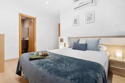 a bedroom with a large bed with a tray on it at Lodging Apartments Villarroel apartment in Barcelona