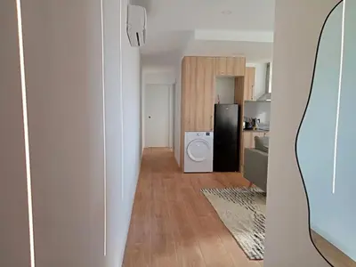 a kitchen and a living room with a black refrigerator at Ático cerca Playa y centro a 10 min. in Sant Adria de Besos