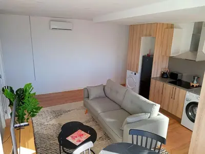 a living room with a couch and a kitchen at Ático cerca Playa y centro a 10 min. in Sant Adria de Besos