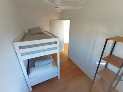 a small white bunk bed in a room at Ático cerca Playa y centro a 10 min. in Sant Adria de Besos