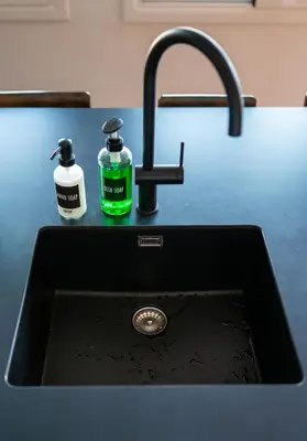 a black kitchen sink with two bottles of soap at jacuzzi privado con vistas increíbles el Raco d Artes in Artés