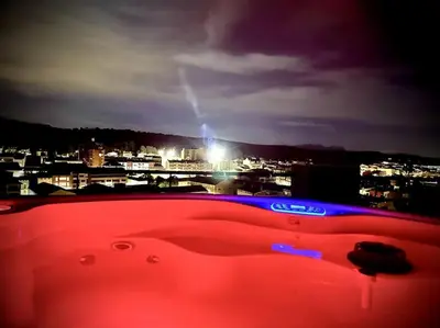 a red tub with a view of a city at night at jacuzzi privado con vistas increíbles el Raco d Artes in Artés