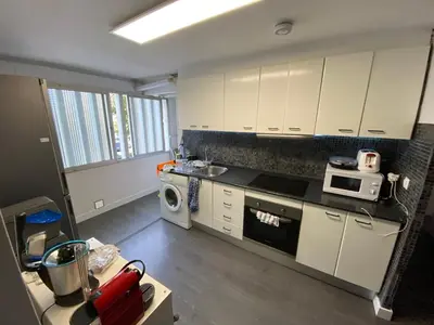 a small kitchen with white cabinets and a microwave at Habitaciones cerca del centro de Barcelona, Barceloneta, Aeropuerto y Fira in Hospitalet de Llobregat