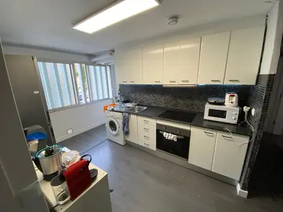 a kitchen with white cabinets and a stove top oven at Habitaciones cerca del centro de Barcelona, Barceloneta, Aeropuerto y Fira in Hospitalet de Llobregat