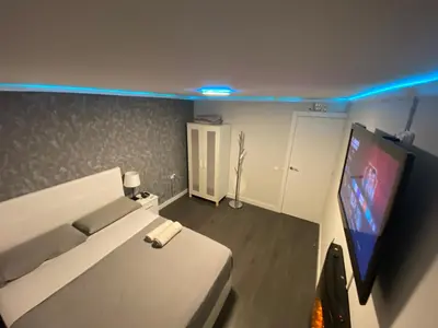 a bedroom with a bed and a flat screen tv at Habitaciones cerca del centro de Barcelona, Barceloneta, Aeropuerto y Fira in Hospitalet de Llobregat