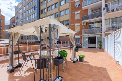 a patio with a table and umbrella on a balcony at ApartEasy - Private terrace, 3 bedrooms, Eixample in Barcelona