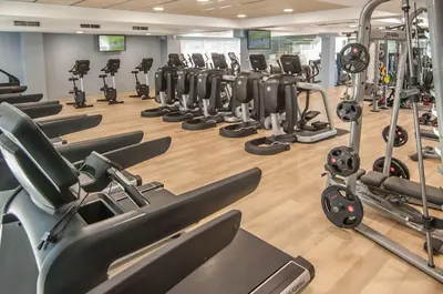 a gym with rows of exercise bikes and treadmills at Hotel Sorli Emocions in Vilassar de Dalt