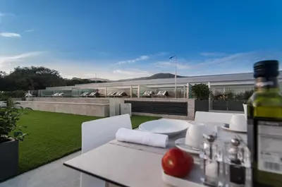 a patio with a table and chairs and a building at Hotel Sorli Emocions in Vilassar de Dalt