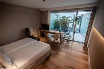 a bedroom with a bed and a desk with a computer at Hotel Sorli Emocions in Vilassar de Dalt