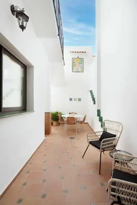 a hallway with chairs and a table in a building at Casa familiar junto al mar en Arenys de Mar in Arenys de Mar