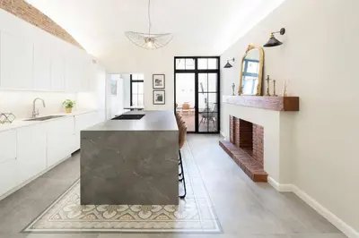 a kitchen with a black counter and a fireplace at Casa familiar junto al mar en Arenys de Mar in Arenys de Mar