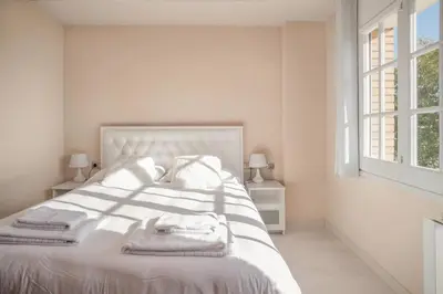 a bedroom with a white bed with towels on it at Comodidad y estilo en Gava near the beach 10 minutes in Viladecáns
