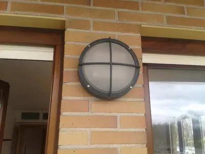 a round mirror on the side of a brick wall at Habitacion con Piscina in Sant Cugat del Vallès