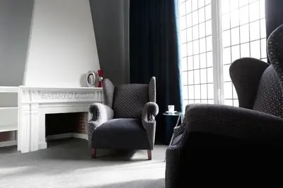 a living room with two chairs and a fireplace at Amra Barcelona Gran Via in Barcelona