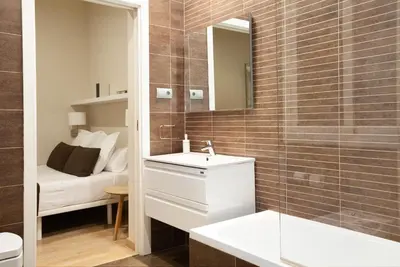 a bathroom with a sink and a mirror and a bed at Easysleep Borne in Barcelona