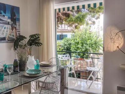 a room with a balcony with a table and chairs at Aolani Apartment by Hello Homes Sitges in Sitges