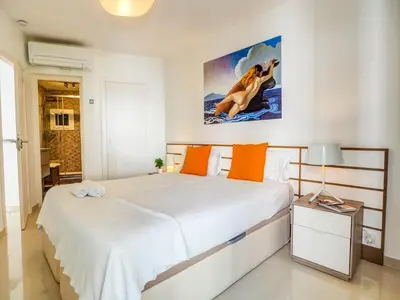 a bedroom with a bed and a painting on the wall at Aolani Apartment by Hello Homes Sitges in Sitges