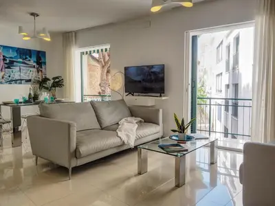 a living room with a couch and a table at Aolani Apartment by Hello Homes Sitges in Sitges