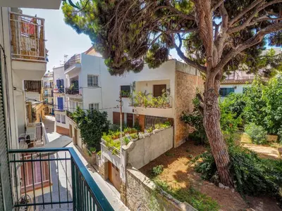 a balcony with a tree in front of a building at Aolani Apartment by Hello Homes Sitges in Sitges