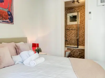 a bedroom with a white bed with towels on it at Aolani Apartment by Hello Homes Sitges in Sitges