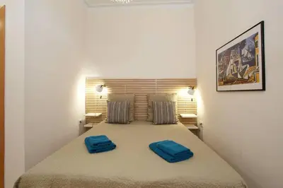 a bedroom with a large bed with two blue pillows on it at Beautiful apartment in Eixample in Barcelona
