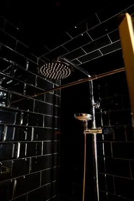 a shower in a bathroom with a black tiled wall at Hotel Lincoln Lounge in Barcelona