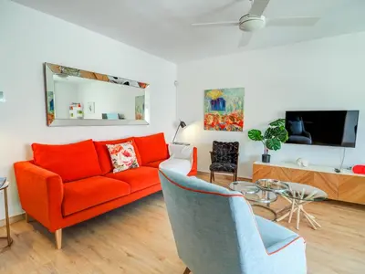 a living room with an orange couch and a table at Happy Diamond by Hello Homes Sitges in Sitges