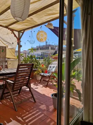 a patio with a table and a chair under an umbrella at Atico Soleado in Esplugues de Llobregat