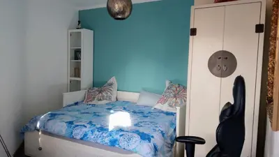 a bedroom with a bed with a blue wall at Atico Soleado in Esplugues de Llobregat