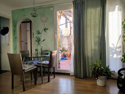 a dining room with a table and chairs and a window at Atico Soleado in Esplugues de Llobregat