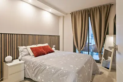 a bedroom with a bed and a large window at YOUR HOME- Apartment Camp Nou Baj in Hospitalet de Llobregat